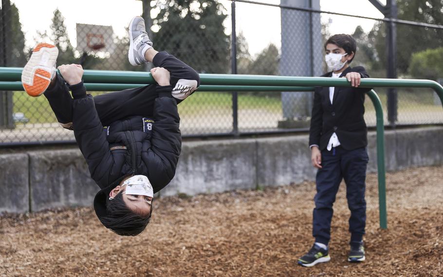 Brothers Mirwais, 7, and Awais, 9, run around the playground at their new school, Southern Heights Elementary, as they get a tour on Feb. 16, 2022, in Burien, Washington.