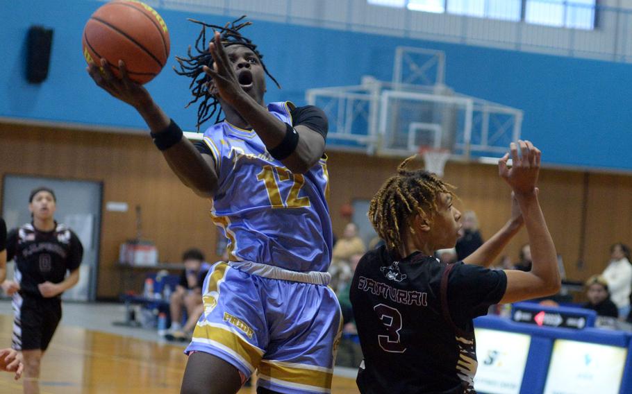 Yokota's Jai Bailey goes up to shoot against Perry's B.J. Hill. The Samurai won 46-39.