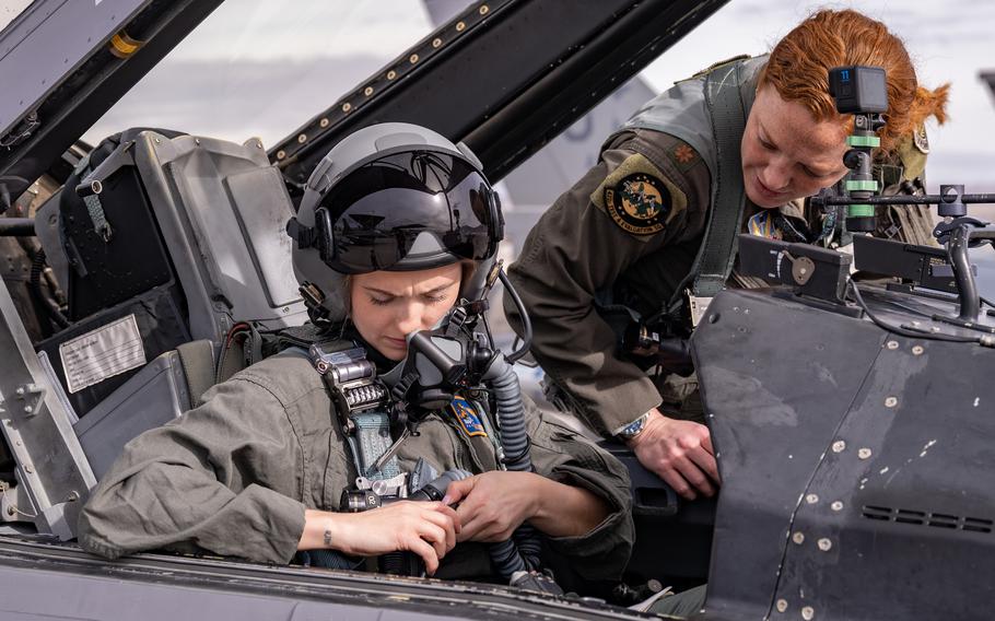 U.S. Air Force 2nd Lt. Madison Marsh, left, gets buckled in for her familiarization flight at Nellis Air Force Base, Nev., Dec. 19, 2023. 