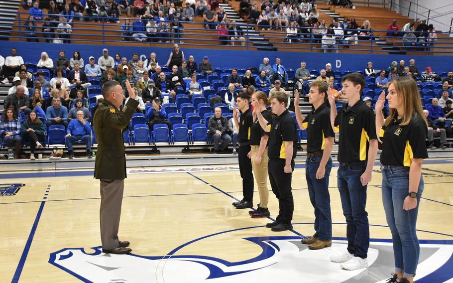 Lt. Gen. Daniel Karbler, commanding general of the U.S. Army Space and Missile Defense Command, administers the oath of enlistment Jan. 21, 2023, to six recruits during Military Appreciation Night at the University of Alabama in Huntsville.