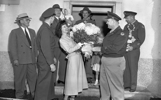 Wiesbaden, Germany Oct. 13, 1949: Maj. C.R. Hall, Wiesbaden's post billeting officer, presents a bouquet to Mrs. Eunice Steed, wife of Capt. Cecil V. Steed, adjutant of the 7167th Special Air missions Squadron (second from left), welcoming them as the first tenants in Wiesbaden's new German-financed apartments project. Also attending the festive welcome is Dr. James R. Newman, land commissioner for Hesse, holding the youngest Steed child,  Hans Redlhammer, Wiesbaden's lord mayor (standing in the doorway), and Brig. Gen. F.R. Upthegrove, Wiesbaden Post CG, holding the ceremonial key.

Looking for Stars and Stripes’ historic coverage? Subscribe to Stars and Stripes’ historic newspaper archive! We have digitized our 1948-1999 European and Pacific editions, as well as several of our WWII editions and made them available online through https://starsandstripes.newspaperarchive.com/

META TAGS: Europe; Germany; military life; military housing; dependent housing; dependents; military family