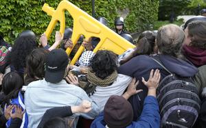 Pro-Palestinian protesters push back as University of Chicago police officers reposition a barricade keeping protesters from the university's quad while the student encampment is dismantled Tuesday, May 7, 2024, in Chicago. (AP Photo/Charles Rex Arbogast)