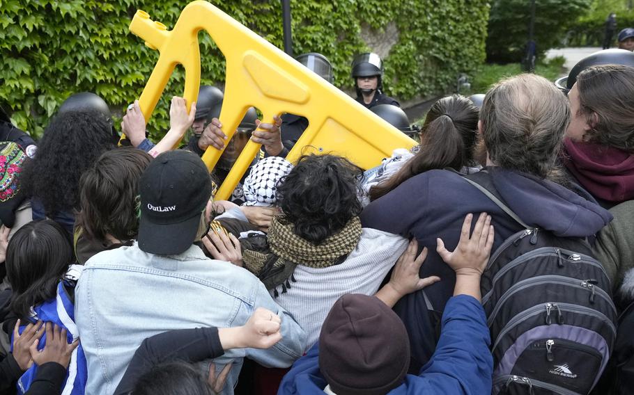 Pro-Palestinian protesters push back as University of Chicago police officers reposition a barricade keeping protesters from the university’s quad while the student encampment is dismantled Tuesday, May 7, 2024, in Chicago.