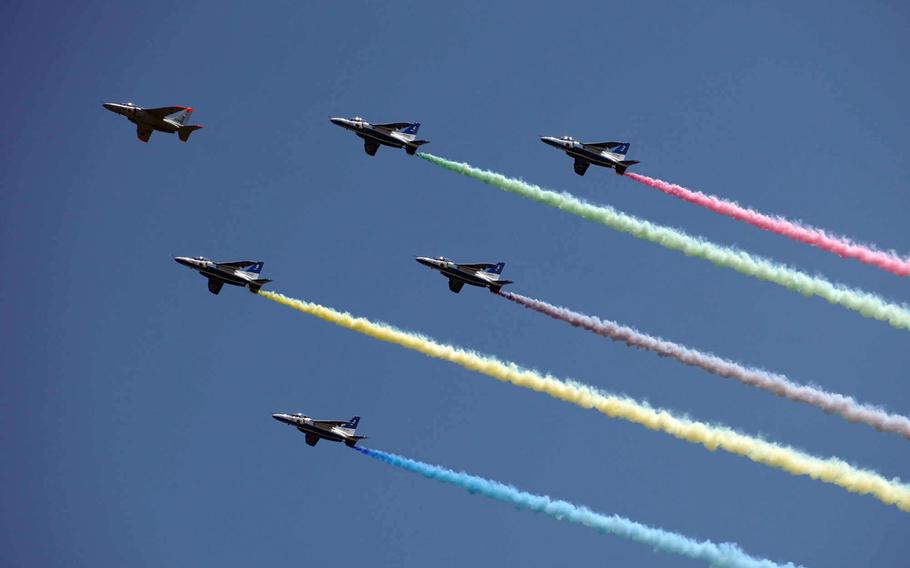 The Japan Air Self-Defense Force's Blue Impulse aerobatic team flies over New National Stadium ahead of the Tokyo Olympics' opening ceremony, Friday, July 23, 2021.