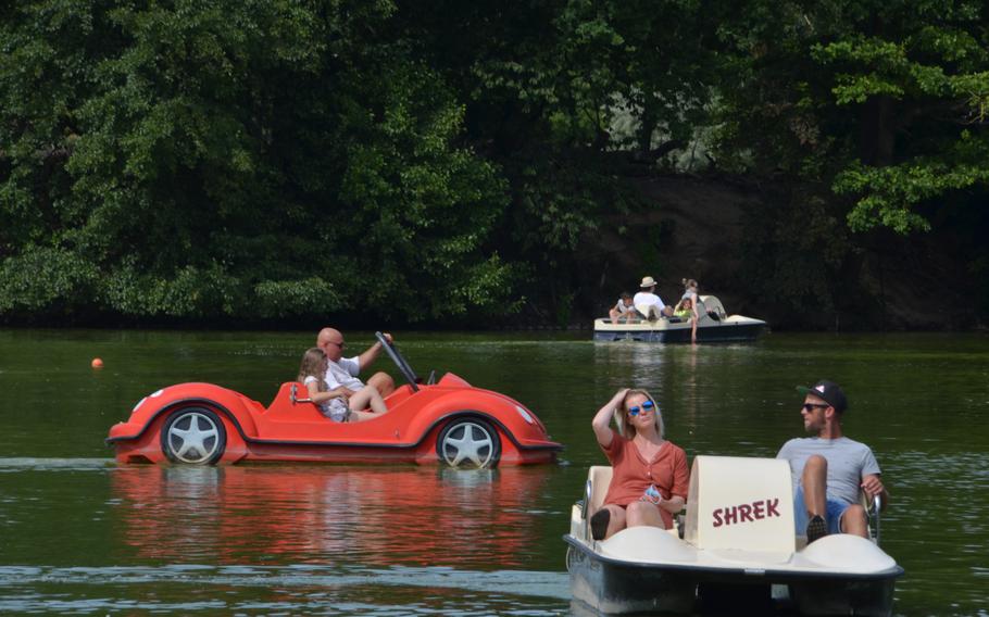 People ride in paddle boats on the lake in the Kurpark in Bad Nauheim, Germany, Aug. 15, 2021. The lake, the park and paddle boats are some of the attractions of the spa town, where Elvis Presley lived from 1958-1960. 