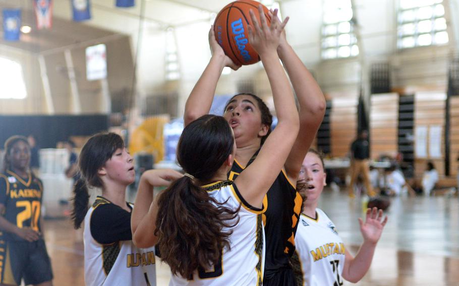 Kadena's Isa Toro Velasquez shoots over American School In Japan defenders during Saturday's Okinawa-American Friendship Tournament pool-play game. The Mustangs outlasted the Panthers 42-40 in extra time.