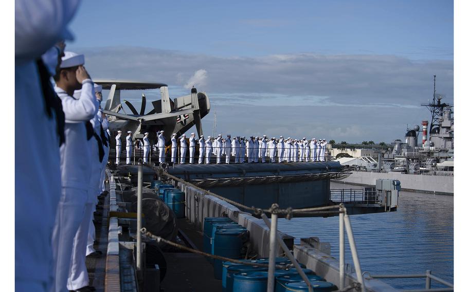 Sailors render honors to the USS Arizona Memorial as Nimitz-class aircraft carrier USS Carl Vinson (CVN 70) pulls into Pearl Harbor, Hawaii, for a scheduled port visit on Feb. 13, 2024. Vinson, flagship of Carrier Strike Group ONE, was underway conducting routine operations in the U.S. 3rd Fleet area of operations. 