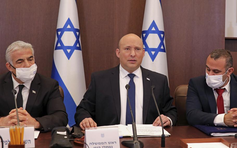 Israeli Prime Minister Naftali Bennett, center, chairs a weekly cabinet meeting, at the prime minister’s office in Jerusalem, Sunday, Dec. 5, 2021. Bennett on Sunday urged world powers to take a hard line against Iran in negotiations to curb the country’s nuclear program, as his top defense and intelligence officials headed to Washington amid the flailing talks.