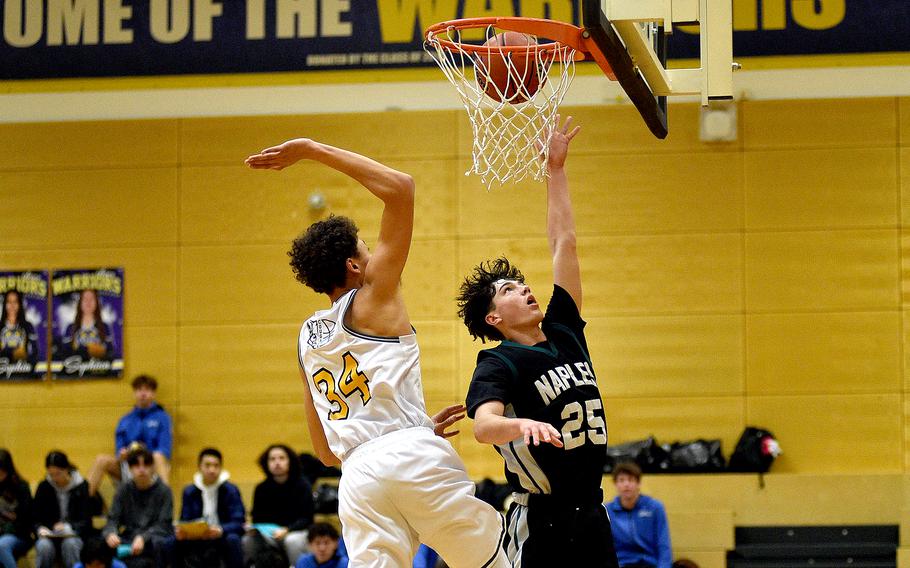 Naples junior Jettyn Jones goes up for a layup while Vicenza sophomore Simon Gilbert tries to block the shot in pool-play action of the DODEA European Basketball Championships on Feb. 15, 2024, at Wiesbaden High School in Wiesbaden, Germany.