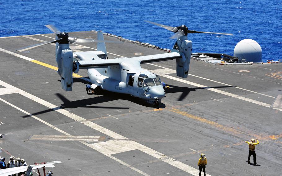 Aviation boatswain's mates chock and chain an MV-22B Osprey in an August 2014 image.