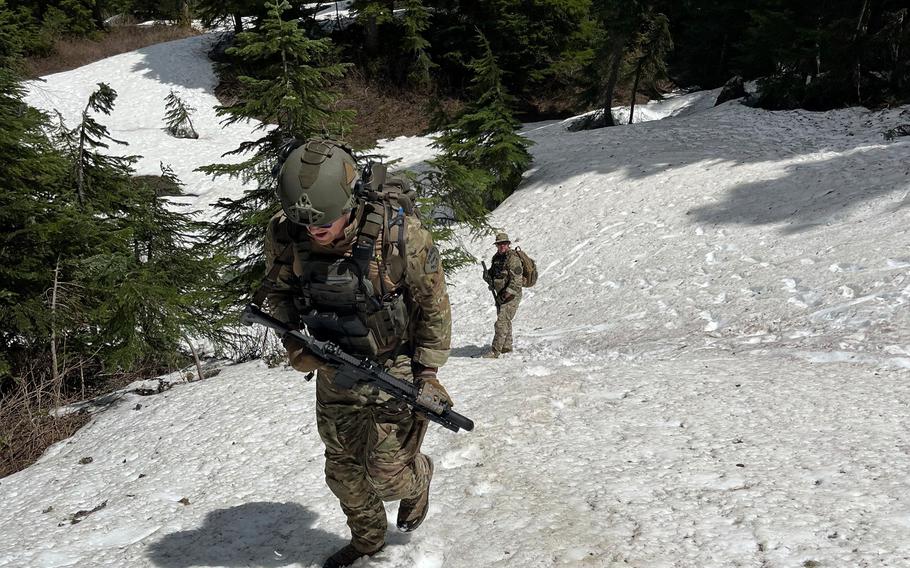Deputies hike up a snowy hill in the woods in search of a suspect.