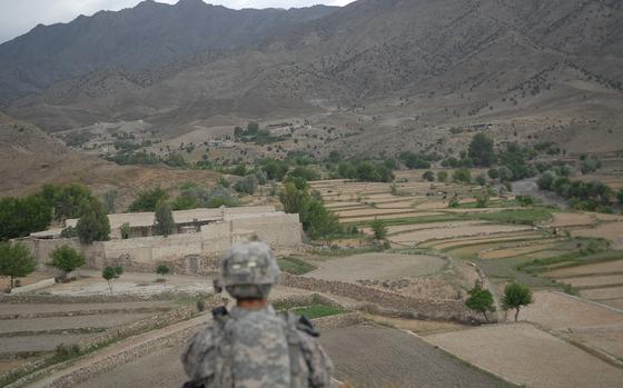 Shembowat, Afghanistan, June 14, 2009: An American soldier stands guard on a hilltop in the village of Shembowat, Afghanistan, as U.S. and Afghan forces pay a visit after a rocket was fired from the area toward their base, Camp Clark, just a few miles away. The village is often the point of origin of mortar and rocket fire, as villagers straddle the fence under threat from Taliban and insurgent fighters not to cooperates with the government or U.S. and coalition forces.

Read Dianna Cahn's 2009 article on Camp Clark here https://www.stripes.com/news/it-s-pretty-unfriendly-down-there-1.92888

MATA TAGS: Afghanistan, Operation Enduring Freedom, Wars on Terror, U.S. Army, Camp Clark, Taliban, 