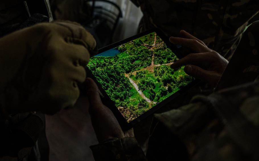 Snipers outside Maryinka check drone footage with soldiers. 