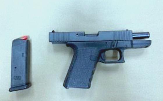 A black handgun and its magazine are shown.