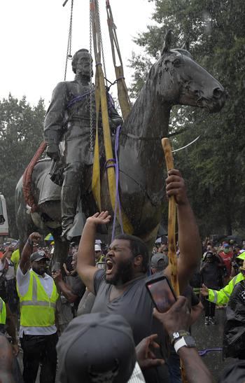 People in the crowd rejoice as a crane crew removes the statue of Confederate Gen. Stonewall Jackson from Monument Avenue in Richmond in July 2020.
