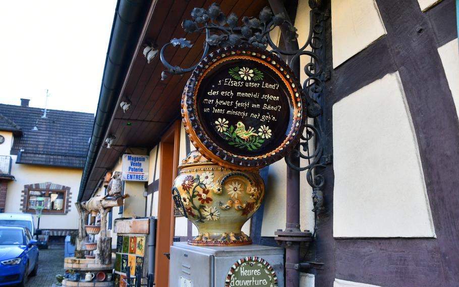 A sign with a message in the Alsatian dialect hangs outside the Ignace Friedmann pottery workshop and store in Soufflenheim, France, on Nov. 8, 2021. Nicknamed “the village of potters,” Soufflenheim is home to around a dozen workshops that produce traditional Alsatian pottery.
