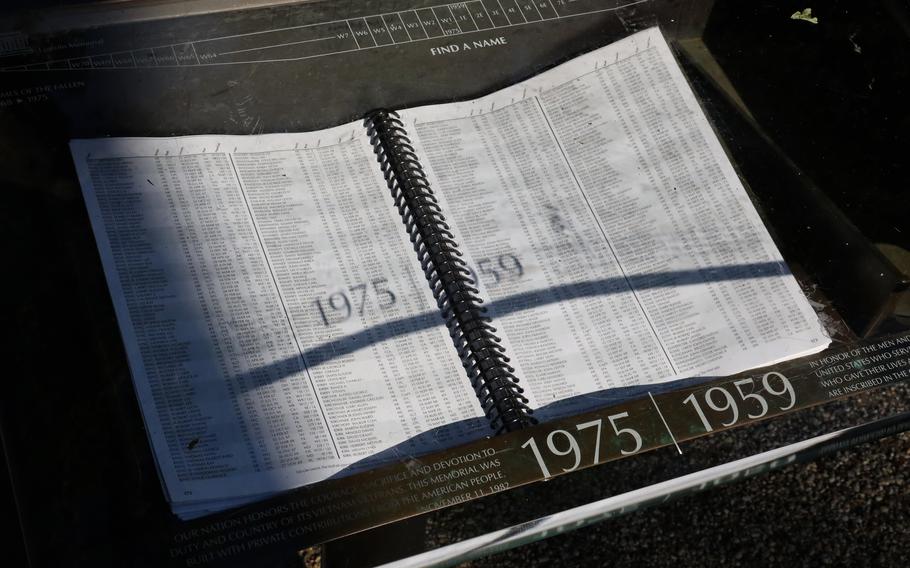 The sun casts a shadow on a book containing information on the location of names on the Vietnam wall, May 31, 2021.