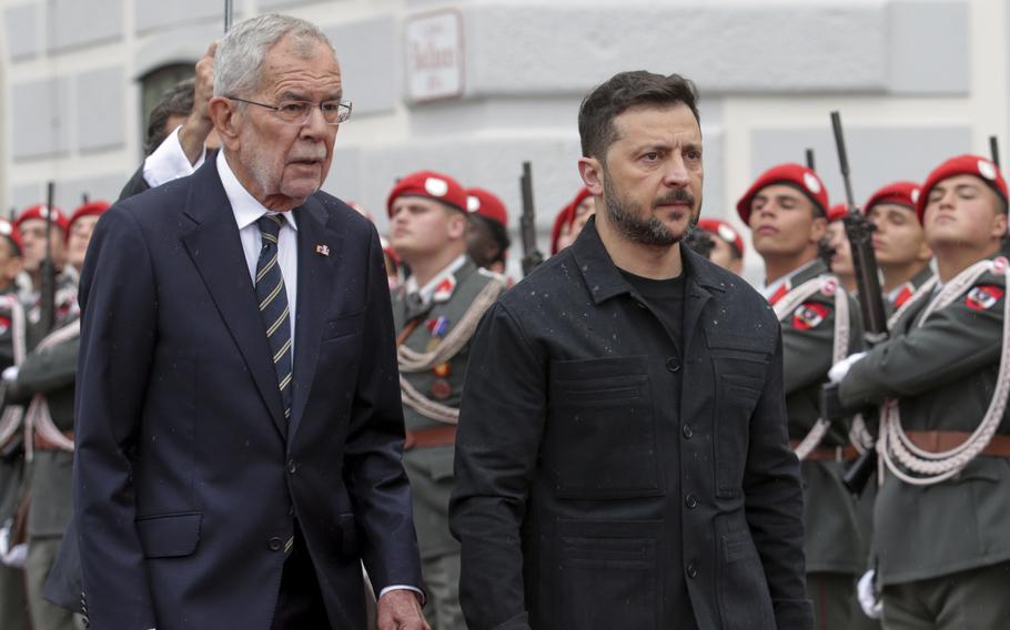 two men walk in front of a crowd of solders.