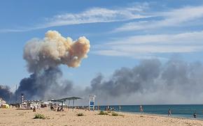 Rising smoke can be seen from the beach at Saky after explosions were heard from the direction of a Russian military airbase near Novofedorivka, Crimea, Tuesday Aug. 9, 2022. The explosion of munitions caused a fire at a military air base in Russian-annexed Crimea Tuesday but no casualties or damage to stationed warplanes, Russia's Defense Ministry said. 