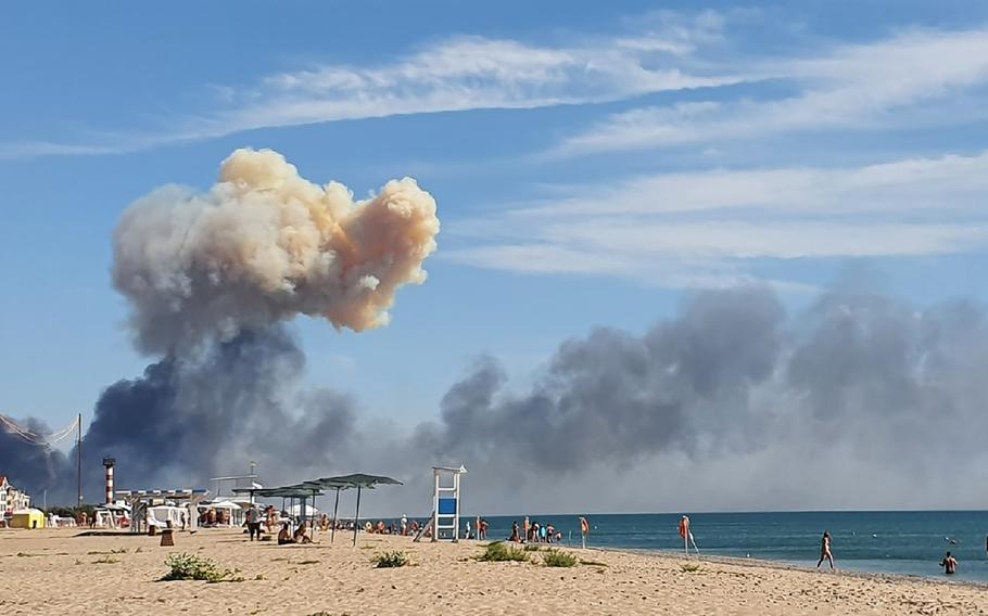 Rising smoke can be seen from the beach at Saky after explosions were heard from the direction of a Russian military airbase near Novofedorivka, Crimea, Tuesday Aug. 9, 2022. 