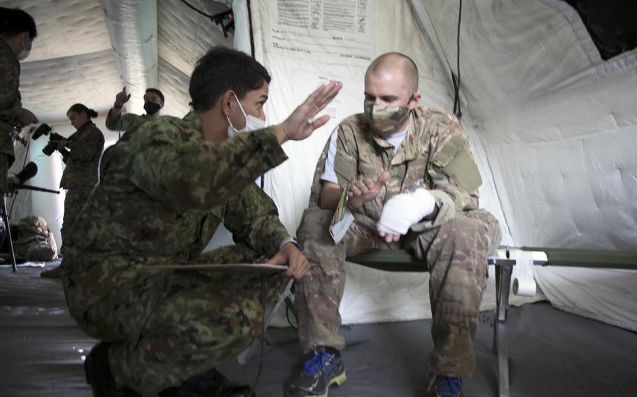 A Japan Ground Self-Defense Force medic checks the vital signs of a U.S. airman acting as an earthquake victim during the Remote Island Disaster Exercise on Okinawa, Tuesday, Nov. 2, 2021.