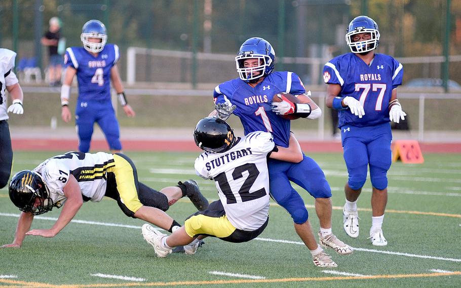 Royal running back Jackson Arthaud tries to break the tackle of Stuttgart defender Jonathon Vernetti during a football game on Sept. 8, 2023, as Ramstein High School on Ramstein Air Base, Germany. Following at right is Ramstein lineman Matt Rutlege.