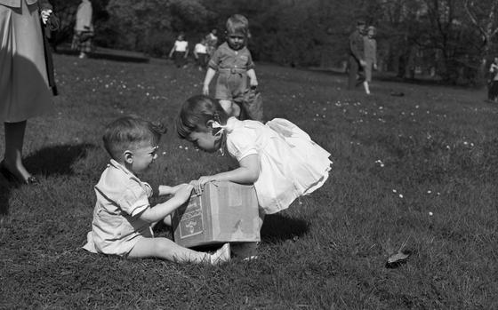 Frankfurt, Germany, Apr. 17, 1949: Two children look unhappy to put all their eggs in one shared box during the annual Easter Egg hunt. Children scoured the grounds of the Palmgarten, Frankfurt’s botanical Palm Garden, for eggs on Easter Sunday. Baskets, bags, and boxes in hand they ran around trying to find the rainbow-colored eggs in the hopes of finding most of them to take home one of the prizes given out for the most eggs found. The traditional Easter Egg Hunt was sponsored by the local Allied Women’s Club.

META TAGS: Easter; holiday; military family; military life; children; Easter Egg hunt; Botanical garden; Christian holiday; Allied Women's Club of Frankfurt