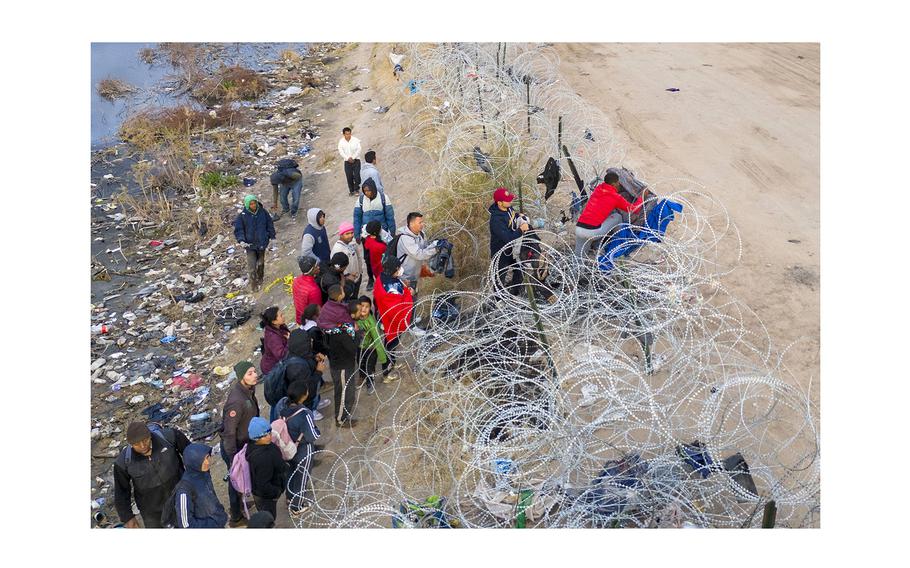 Immigrants try to pass over razor wire after crossing the border into El Paso, Texas from Ciudad Juarez, Mexico. Those who managed to get through the wire were then allowed to proceed for further processing by U.S. Border Patrol agents. 