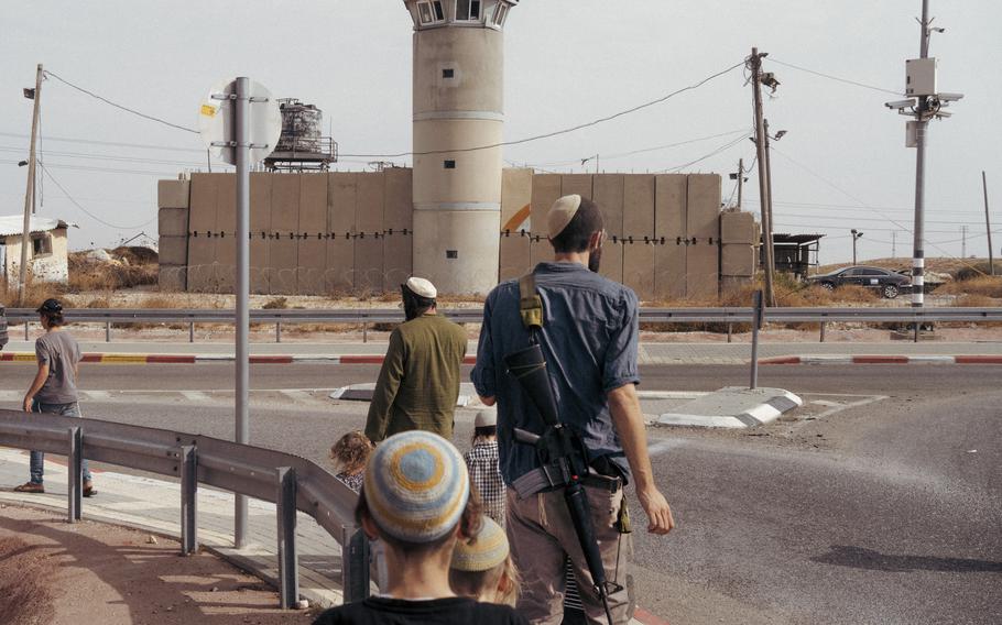 Settlers from Kochav Hashachar in the West Bank march on a road to the Palestinian village of Taybeh on Friday, Oct. 27, 2023. A confrontation between settlers and Palestinian farmers the day before left one settler and several Palestinians injured.