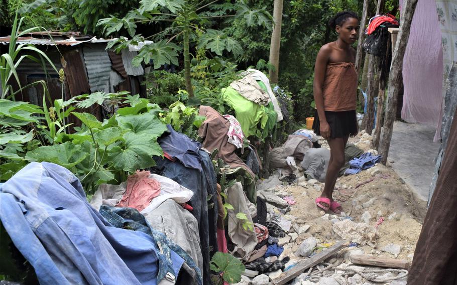 Dyeumen Lacombe stands outside her home damaged by an Aug. 14, 2021 earthquake in southern Haiti. 