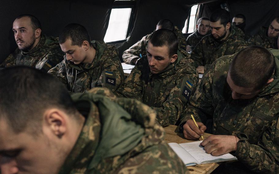 Recruits attend a class on land mines during training. 