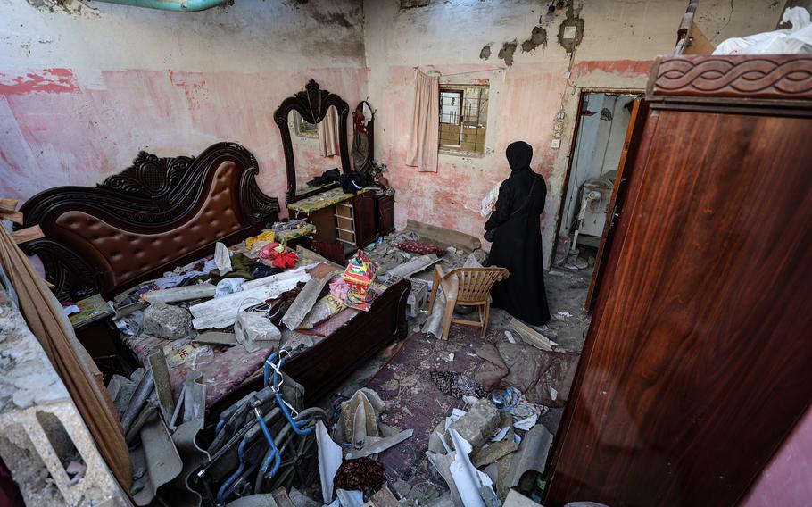 A woman inspects the damage caused by an Israeli airstrike on a home in Rafah on Jan. 18, 2024.