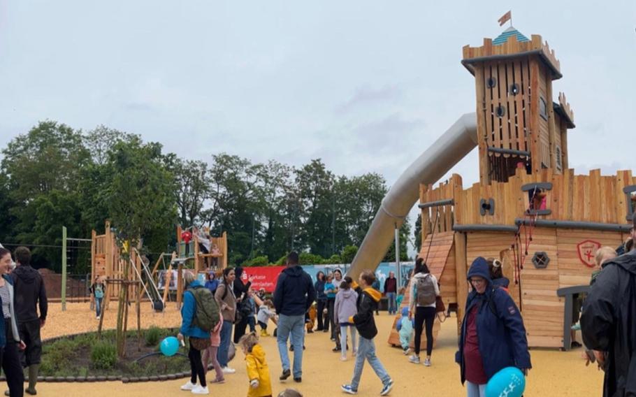 People walk around a playground.