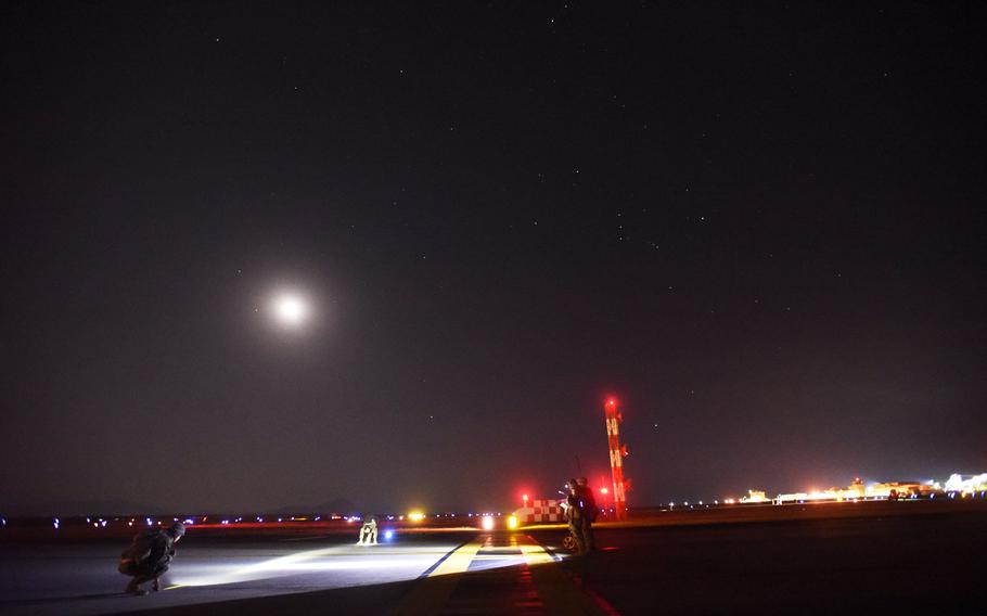 Combat engineer Marines measure simulated damage to the flight line after a mock attack that was part of the Active Shield exercise at Marine Corps Air Station Iwakuni, Japan, Oct 28, 2021.