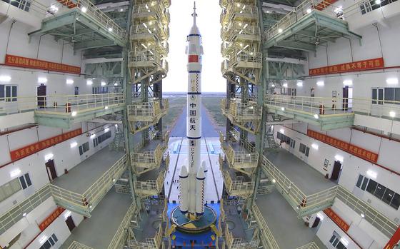 FILE - In this photo released by Xinhua News Agency, the Shenzhou-13 manned spaceship onto of a Long March-2F carrier rocket prepares to be transferred to the launching area of Jiuquan Satellite Launch Center in northwestern China, Oct. 7, 2021. China is preparing to send three astronauts to live on its space station for six months — a new milestone for a program that has advanced rapidly in recent years.  It’s not just rocket fuel propelling America’s first moonshot after a half-century lull. Rivalry with China’s space program is helping drive NASA’s effort to get back into space in a big way. That's as both nations push to put people back on the moon and establish the first lunar bases. (Wang Jiangbo/Xinhua via AP, File)