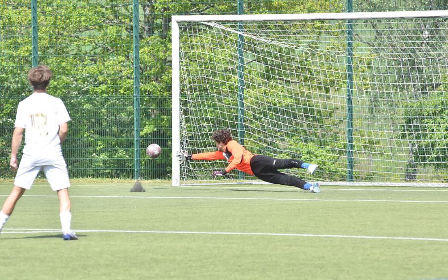 Wiesbaden goalkeeper Evan Cook dives to try to save a shot Wednesday, May 17, 2023 in the semifinals of the DODEA-Europe Division I soccer championships. The shot hit the post and bounced away.