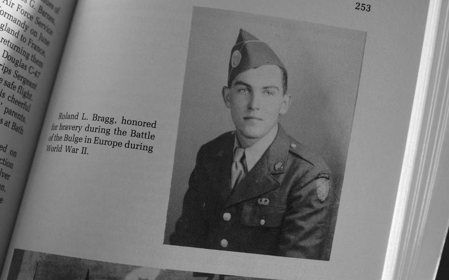 An open book showing page 253 with a black and white military portrait photograph of Roland L. Bragg in Air Force uniform, with accompanying text describing his honor for bravery during the Battle of the Bulge in Europe during World War II.