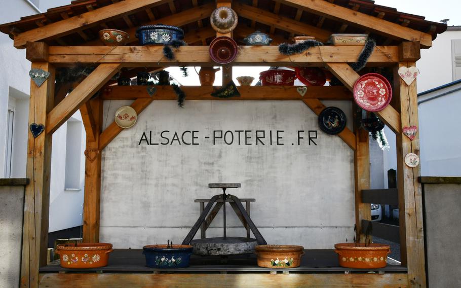 A display of traditional Alsatian pottery, including terrines and gugelhupf cake molds, sits in what looks like a bus shelter on the main road through Soufflenheim, France, on Nov. 8, 2021. Dubbed “the village of potters,” Soufflenheim is home to more than a dozen artisanal pottery workshops and stores.