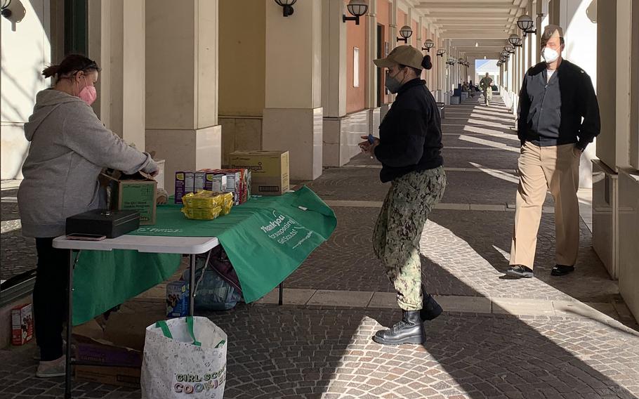 People buy cookies at a Girl Scouts table set up at Naval Support Activity Naples Capodichino site, Feb. 10, 2022. U.S. Army bases in Italy will stop requiring people to wear face masks outdoors on Feb. 11, in accordance with new Italian rules. But some military installations, including NSA Naples, haven't announced any changes and say they will review the Italian decree.  