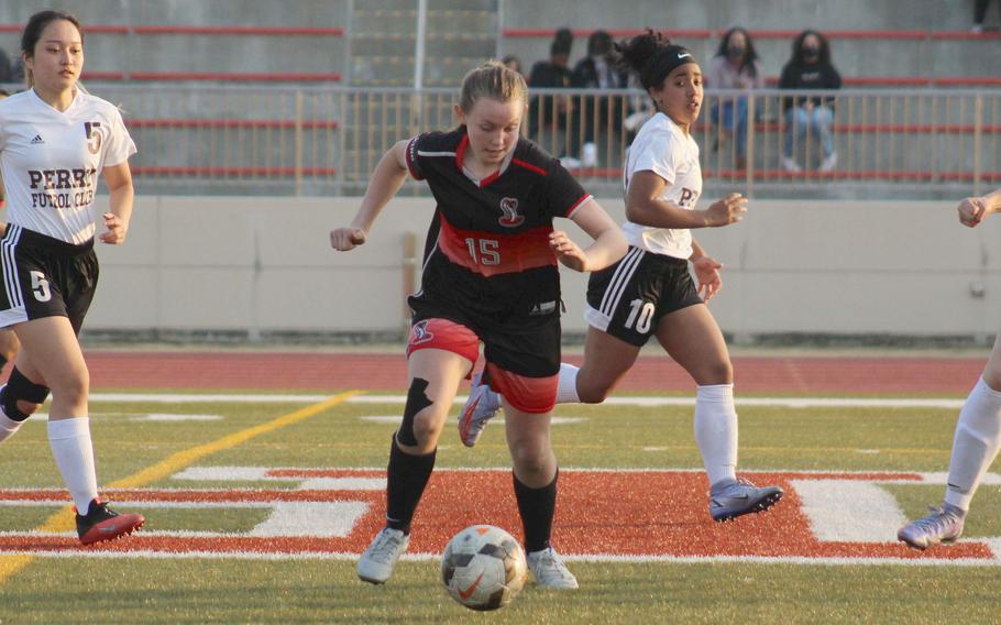 E.J. King's Madylyn O'Neill dribbles between Matthew C. Perry's Towa Albsmeyer, Ella Hewitt and Ivanelis Nievis during Friday's DODEA-Japan soccer match. The teams played to a 1-1 draw.