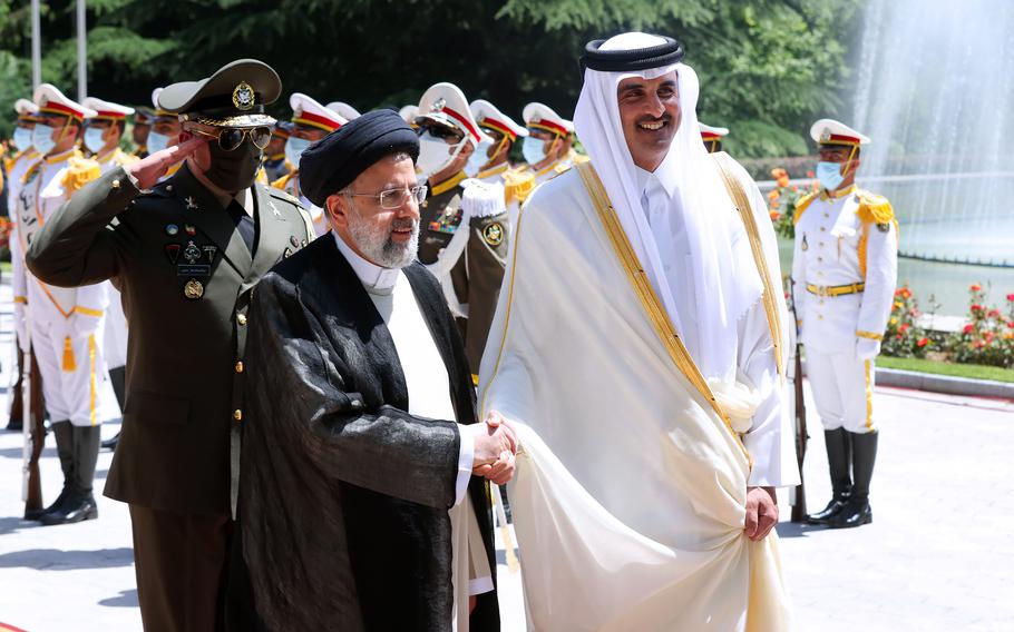In this photo released by the official website of the office of the Iranian Presidency, Qatari Emir Sheikh Tamim bin Hamad Al Thani, right, shakes hands with President Ebrahim Raisi during an official arrival ceremony at the Saadabad Palace in Tehran, Iran, Thursday, May 12, 2022. 