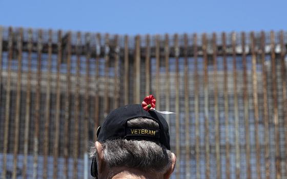 A veteran stands next to the border fence during the "Remembering our Fallen Exile Deported Veterans" event to commemorate the Memorial Day, at the US-Mexico border in Playas de Tijuana, Baja California state, Mexico, on May 29, 2022. (Guillermo Arias/AFP via Getty Images/TNS)