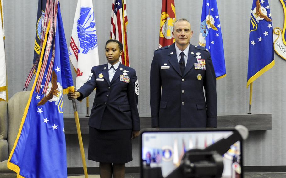 Chief Master Sgt. Kimberly Pollard, National Air and Space Intelligence Center Command Chief, stands with the NASIC flag during a ceremony honoring Col. Maurizio Calabrese as he assumed command of the Center June 9, 2020. Newly promoted Brig. Gen. Calabrese, who relinquished command of NASIC to Col. Ariel Batungbacal last month, will serve as deputy commanding general for intelligence at the Over-the-Horizon Counterterrorism headquarters, U.S. Central Command, at Al Udeid Air Base in Qatar.