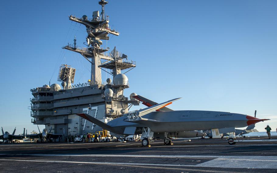 A Boeing unmanned MQ-25 aircraft is given operating directions on the flight deck aboard the aircraft carrier USS George H.W. Bush (CVN 77) on Dec. 13, 2021. The 50-foot-long MQ-25 drone, which can fly 500 nautical miles carrying a load of 16,000 pounds of fuel, will be the world’s first operational, carrier-based unmanned aircraft.