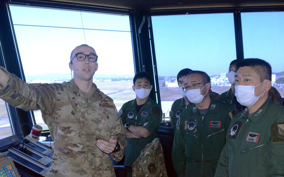 Air Force 1st Sgt. Grant Krause shows Japanese airmen from Komaki Air Base, Nagoya, the control tower at Yokota Air Base in western Tokyo, Thursday, Nov. 4, 2021.