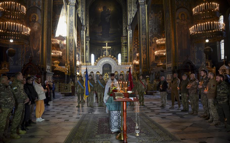 Soldiers from Ukraine and Georgia hold candles as they mourn the death of Gurgen Gagnidze, a Georgian soldier, at a funeral in Kyiv, Ukraine, on Nov. 1, 2022. Gagnidze died fighting Russian forces in east Ukraine in late October. He was a foreign volunteer from the country of Georgia serving in Ukraine’s 25th Airborne Brigade.