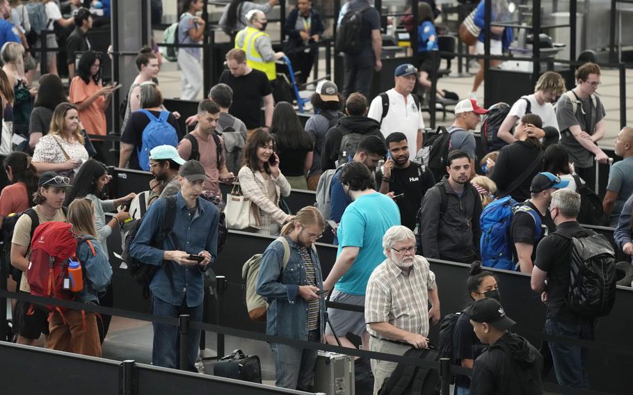 Travelers wait in long lines at a security checkpoint in Denver International Airport Tuesday, July 5, 2022, in Denver. The Fourth of July holiday weekend jammed U.S. airports with the biggest crowds since the pandemic began in 2020. 