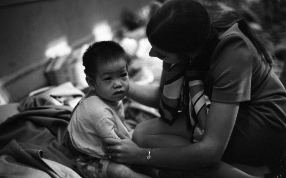 A young child is held by a woman.