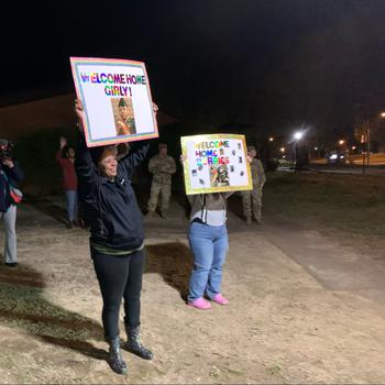 Jayime Mathis, left, holds a sign welcoming home her daughter, Spc. Jayla Mathis, from deployment April 12, 2024, at the Family Life Center on Fort Gregg-Adams, Va.