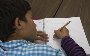 A child writes in a notebook.